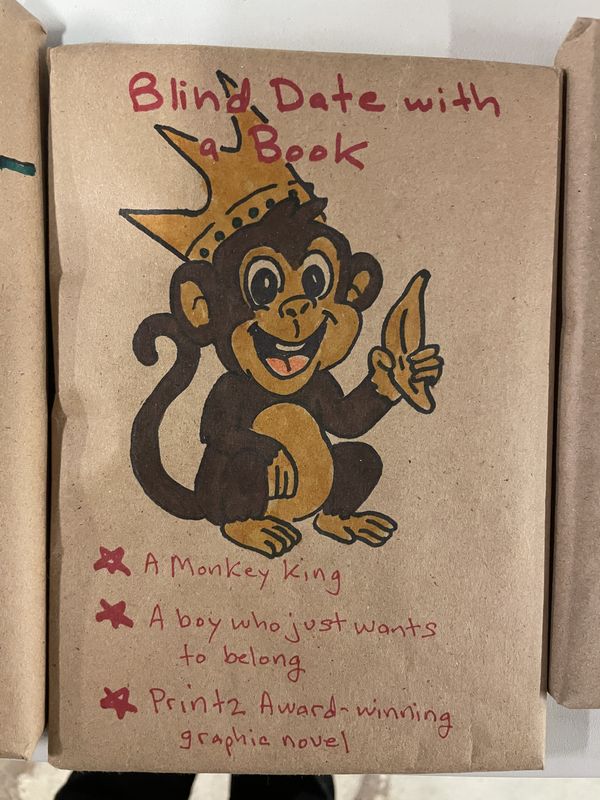 A hand-drawn wrapped book showing a monkey wearing a crown, with hints about a Printz Award-winning graphic novel.