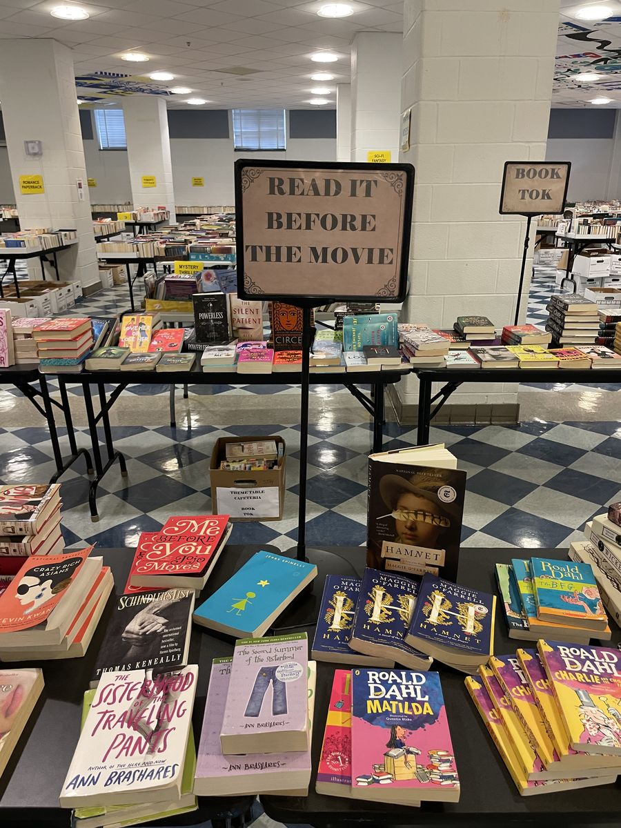 A theme table with a Read It Before The Movie sign, next to a Book Tok display.